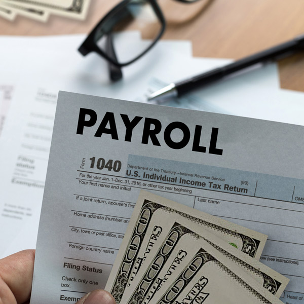 hand holding payroll document and cash